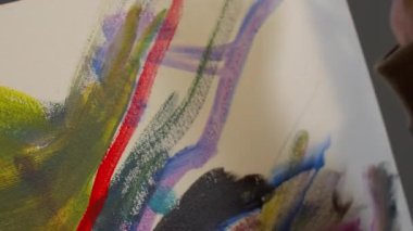 Woman draws a picture with paints, close up