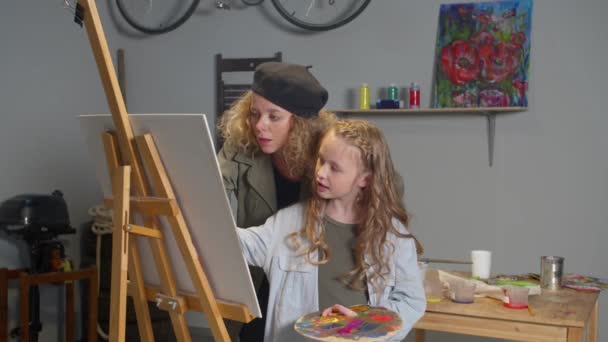 Woman and girl draw together on canvas — Stockvideo