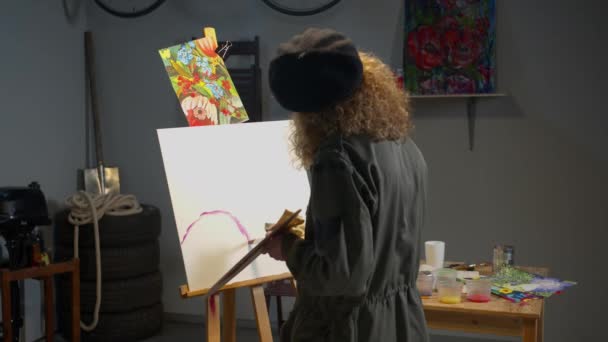 Женщина рисует картину в студии — стоковое видео