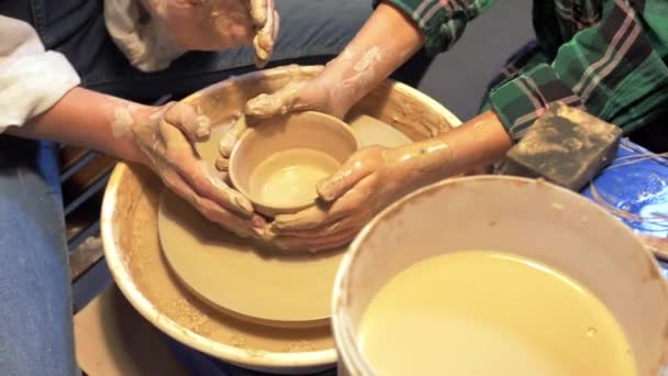 Niño y mujer trabaja con rueda de cerámica en un taller, cámara lenta — Vídeo de stock