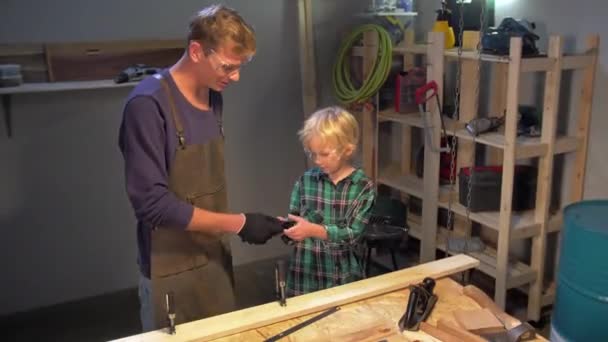 Хлопчик одягає захисні рукавички в майстерню — стокове відео