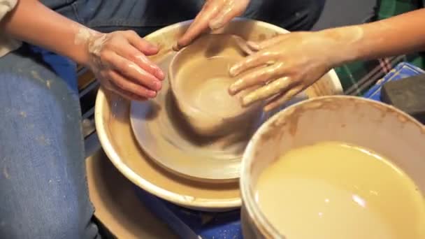 Mujer y niño hacen plato en la rueda de cerámica en el taller — Vídeos de Stock