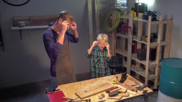 Man en jongen zetten veiligheidsbril op voor het werk. — Stockvideo