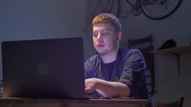 Man zit in de werkplaats met laptop — Stockvideo