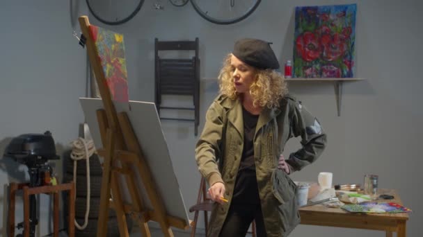 Женщина рисует красочную картину кистью — стоковое видео