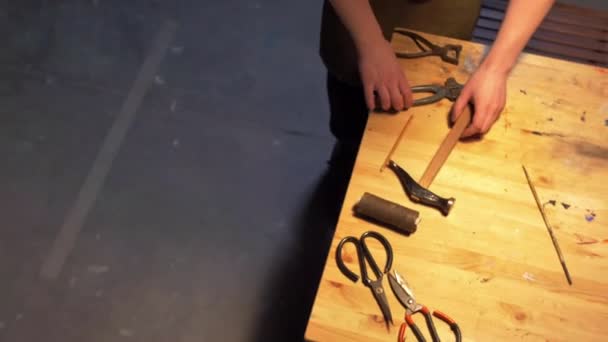El hombre prepara herramientas de trabajo sobre una mesa en un taller — Vídeos de Stock