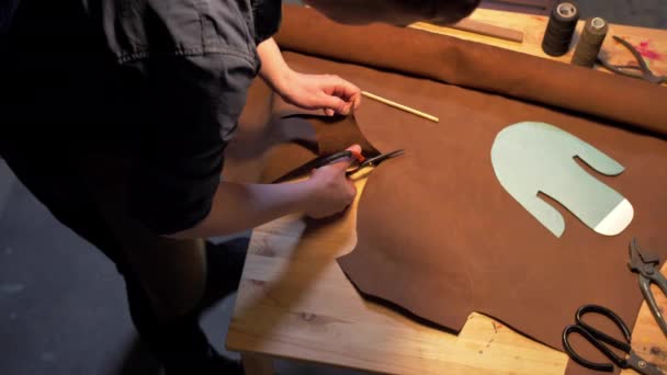 L'homme coupe un morceau de tissu sur une table — Video