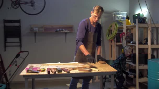 Jongen helpt om gereedschap op de plank te zetten in de werkplaats — Stockvideo