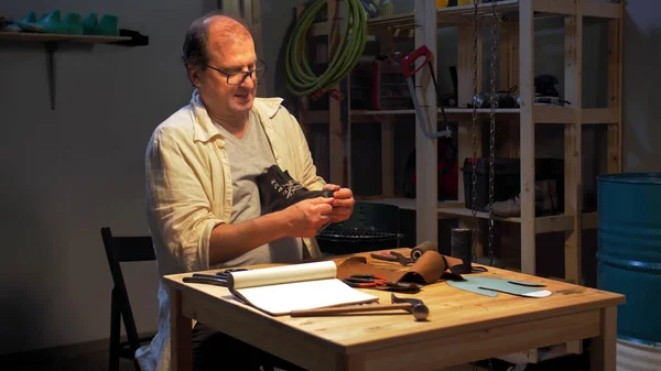 L'homme s'assoit et crée une chaussure dans l'atelier — Photo