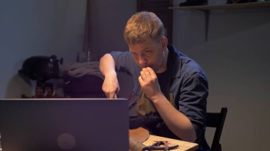 Adam atölyede eğitim videosu izliyor.