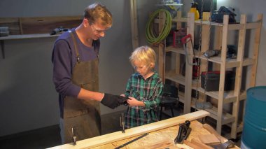 Çocuk atölyede koruyucu eldiven takıyor.