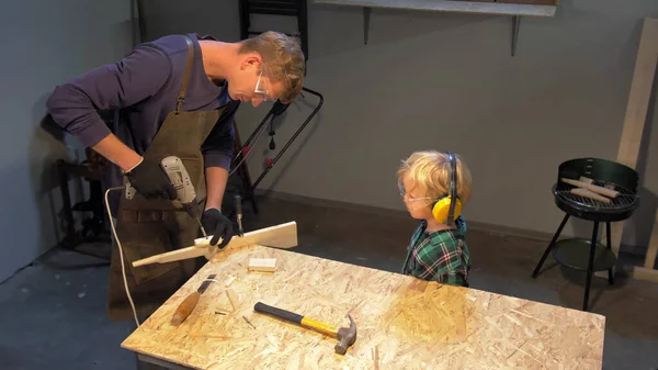 Garçon regarde comment l'artisan fait des produits en bois, au ralenti — Photo