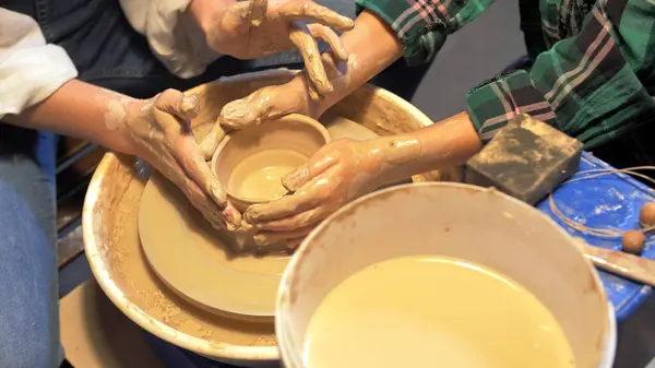 Boy and woman works with pottery wheel in a workshop, slow motion — Stock Photo, Image