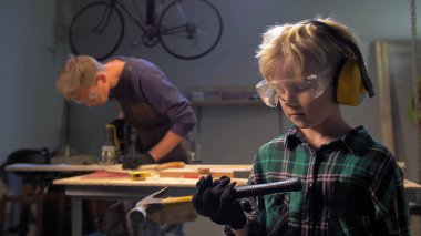 Gözlüklü çocuk duruyor ve çekice bakıyor. 