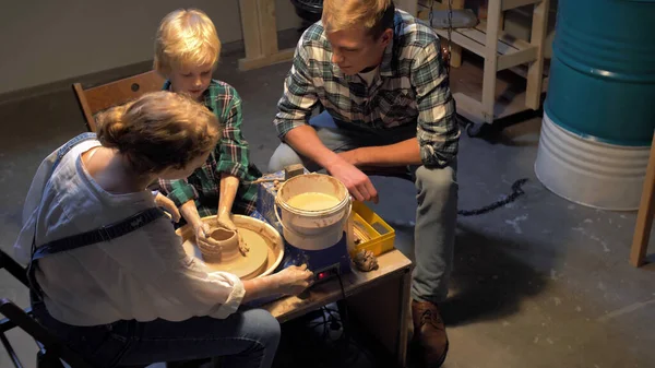 Woman teaches little boy to work with pottery wheel — Stock Photo, Image