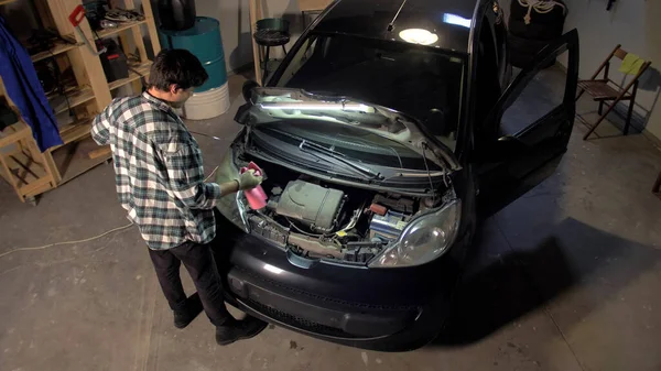 Man reparerar bilmotorn i garaget — Stockfoto