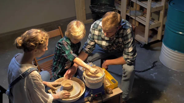 Slow motion, woman teaches man and boy to work with pottery wheel — Stock Photo, Image