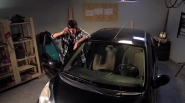 Adam arabanın yanında telefonla konuşuyor.