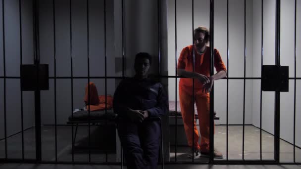 Заключенный разговаривает с охранником через решетку — стоковое видео