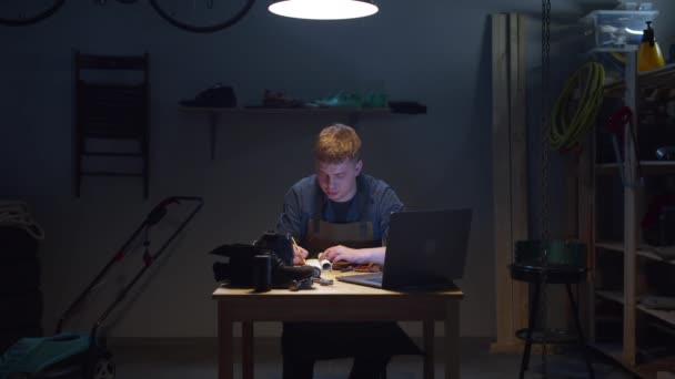 Un uomo guarda informazioni su hobby in un computer portatile — Video Stock