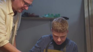 Kızgın ayakkabıcı öğrenciyi hata için cezalandırır.