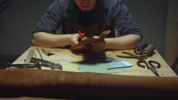 Un curtidor trabaja detrás de un banco de trabajo — Vídeo de stock