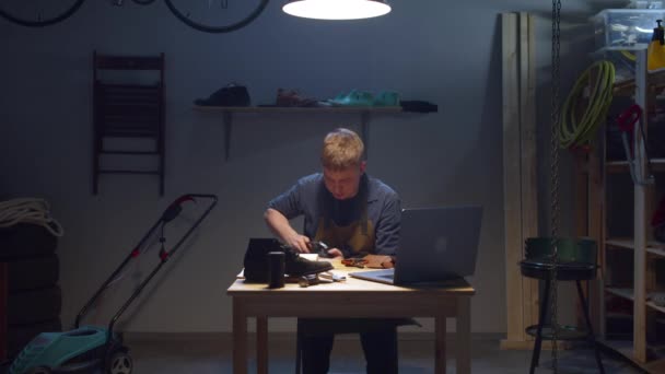 Shoemaker watches lessons on the Internet. Work from home — Stock Video