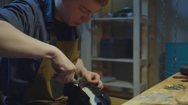 Travailleur dans tablier crée des chaussures dans l'atelier — Photo