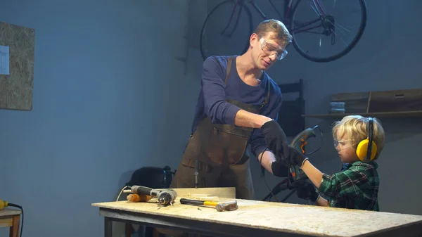 L'homme demande à son fils de lui donner des outils. Atelier garage — Photo