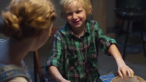 Мама з дитиною дуріють під час уроку з кераміки. — стокове відео