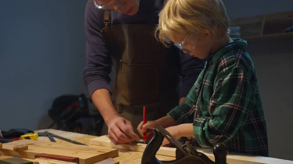 Son and father work on a workbench — Stock Photo, Image