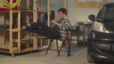 Garajda bir adam dinleniyor. Bira, sigara, kötü alışkanlıklar.