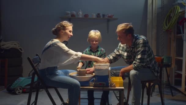 Молодая семья увлечена глиняной моделью в своем гараже — стоковое видео