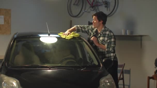 El tipo lava su coche con un trapo. Tiro medio — Vídeos de Stock