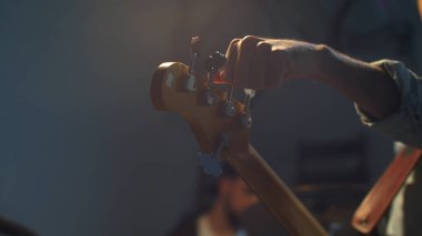 Genç gitaristler enstrümanlarını akort ederler. Kapat.