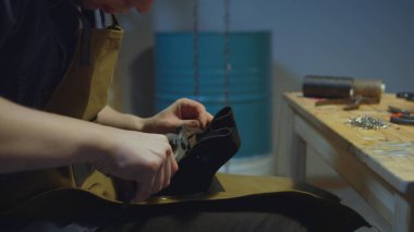 Ayakkabıcı deriyi inceler. El yapımı.