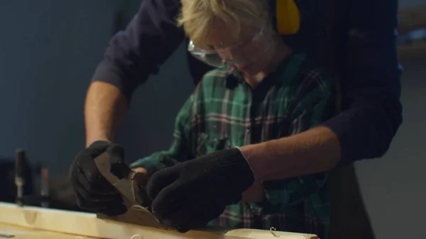 Vader leert zijn zoon een schaafmachine te gebruiken. Vaderschap — Stockfoto