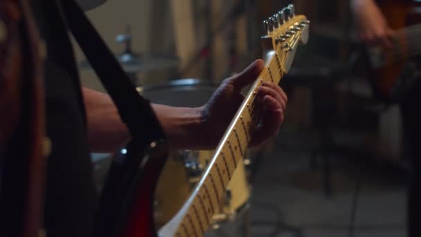 O músico pega as cordas de uma guitarra elétrica. Fechar — Vídeo de Stock
