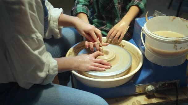 Maman et enfant ensemble font un vase sur une roue de poterie — Video