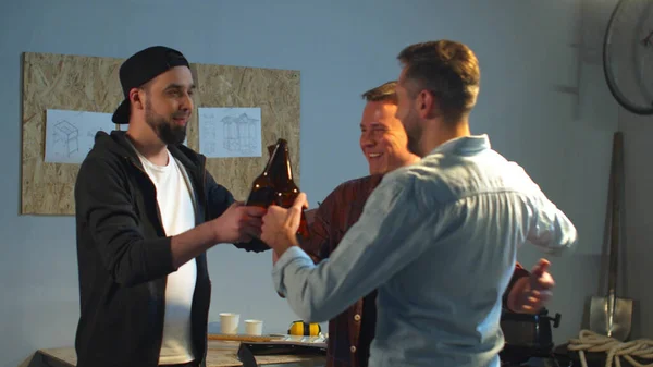 Arkadaşlar garajda bira içer. Orta boy.