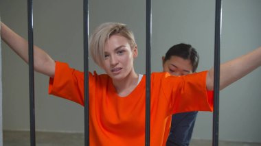 Gardiyan genç bir suçluyu muayene ediyor.