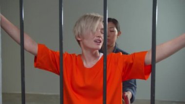 Gardiyan genç bir suçluyu muayene ediyor.