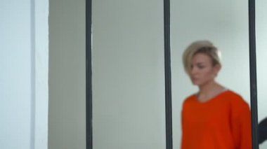 Kadın gardiyan hücresinde bir suçluyu yönetiyor.