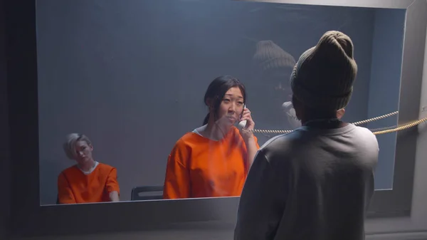 Mahkum, ziyaret odasında bir adamla konuşuyor. Orta boy.