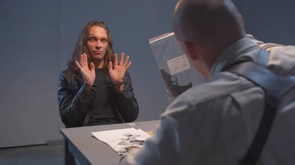 Şüpheli sorgulama sırasında silahı inceliyor.