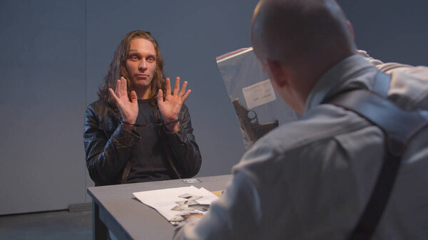 Suspect examines a gun during interrogation