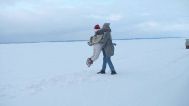 Karlı havada çift sarılmak için döner. Yavaş çekim