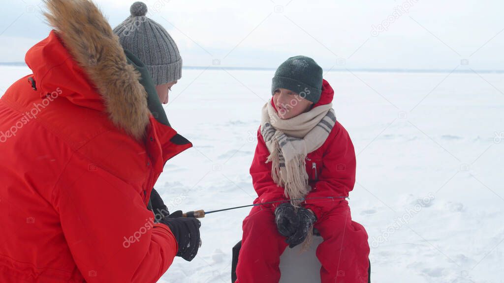 Dad explains to his son how to use a fishing rod