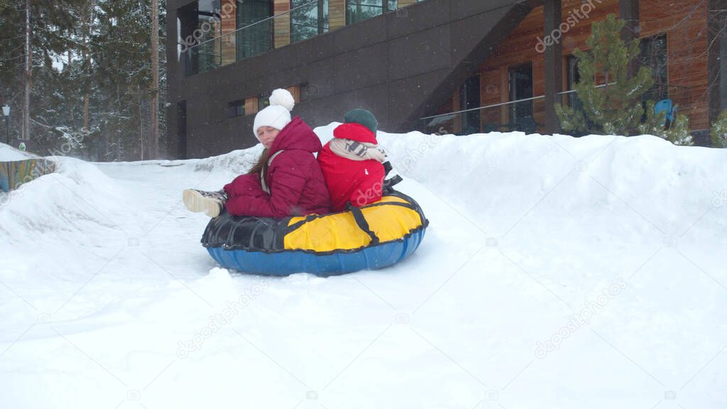 Children ride on an ice slide. Slowmotion