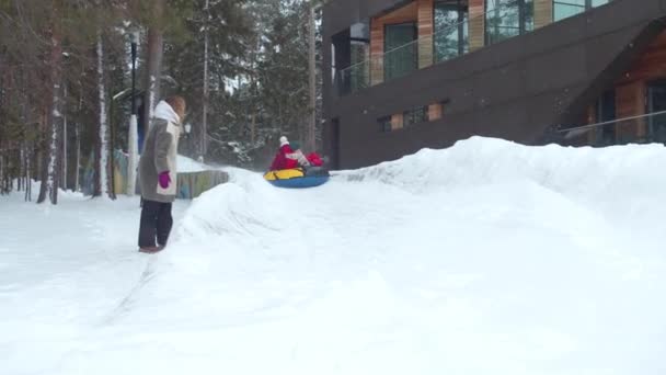 Children ride on an ice slide. Slowmotion — Stock Video